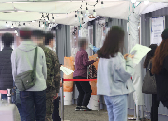 국내 신종 코로나바이러스 감염증(코로나19) 신규 확진자 수가 이틀 연속 500명대를 기록한 1일 오전 서울역광장에 마련된 임시선별진료소에서 시민들이 검사를 받고 있다. <연합뉴스>